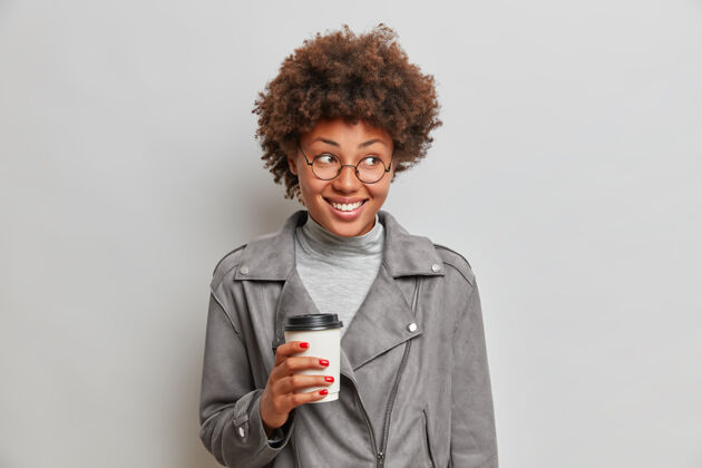 女性摄影棚拍摄的快乐微笑的非裔美国妇女手持纸杯咖啡黑色手非洲