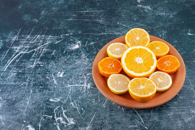 橙子新鲜切碎的柑橘类水果放在一个粘土圆形盘子里克莱门汀柑橘切片