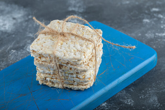 皮用绳子绑在木头砧板上的脆面包烹饪面包谷类
