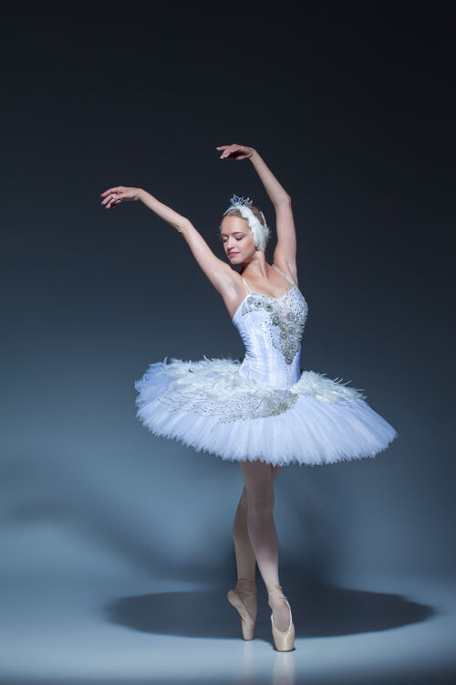 人物芭蕾舞演员在蓝色背景下扮演白天鹅的肖像优雅芭蕾舞芭蕾舞