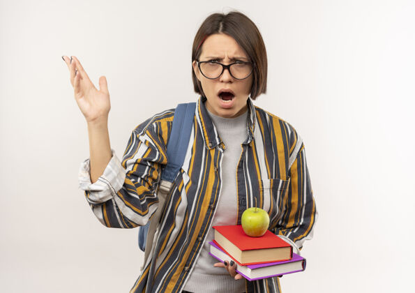 背戴着眼镜 背着书包 手举苹果的书 在白色背景上 有复印空间的未出租的年轻女学生眼镜手包