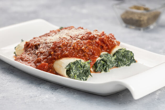 传统特写镜头的意大利香肠菜塞满了菠菜和意大利乳清干酪与博洛尼亚酱美味菜肴乡村