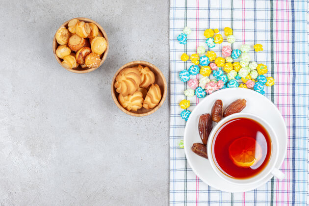 热的大碗饼干和茶 大理石背景上有枣子和糖果高品质照片糖果小吃水果