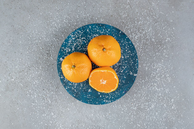 切片椰子粉洒在大理石背景上的橙子盘上粉末美味可口