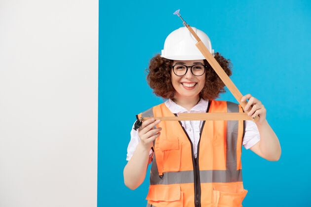 制服正面图微笑的女建筑工人穿着制服 蓝色的木制工具工具工作人