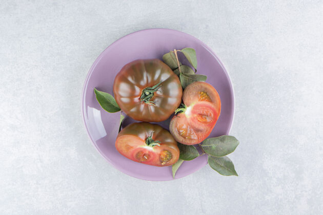 有机在大理石表面的盘子里放上新鲜的西红柿营养番茄美味