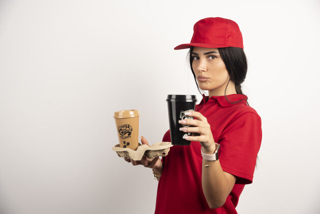 展台严肃的信使摆出两杯咖啡在白色背景上高质量的照片女孩送货员工人