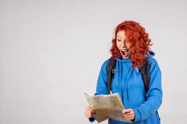年轻带背包和地图的女性游客的正面视图学者知识分子微笑