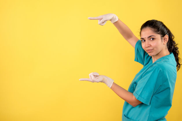 漂亮前视图：女医生戴着乳胶手套 用手显示尺寸女人手黄色