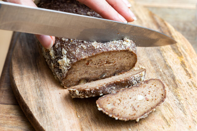 刀用刀切生素食面包的人自然餐桌美味