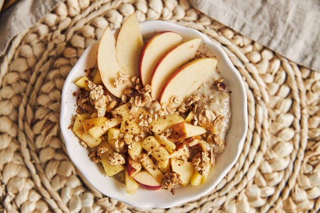 水果高角度拍摄的一碗麦片粥和坚果 以及木桌上的苹果片汤匙零食素食