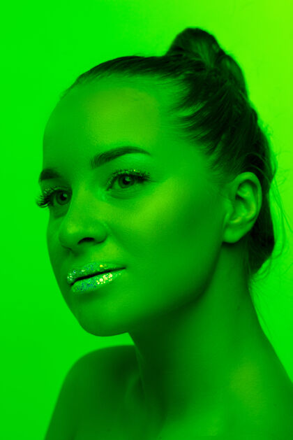 酷在霓虹灯 单色 绿色摄影棚背景上孤立的美女肖像美丽的女性模特人类情感 面部表情 销售 广告 时尚和美丽的概念手势专业霓虹灯