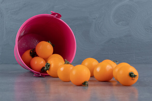 收获一个粉红色的桶装满了成熟美味的黄樱桃番茄小营养农业