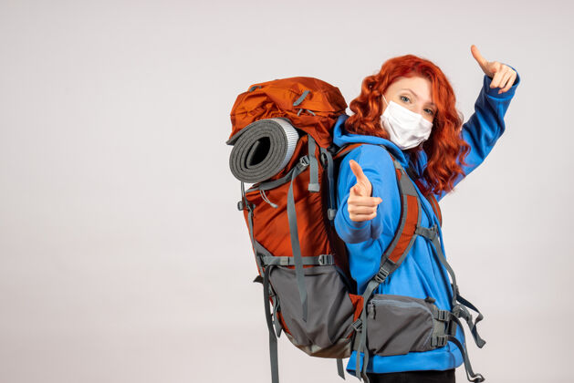 成人正面图女游客带着背包 戴着面具上山旅游背包女游客女人
