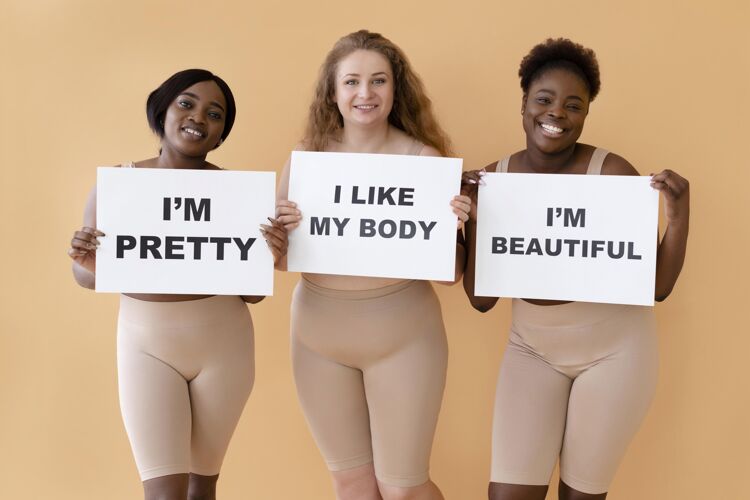 身体积极性三位女士举着写有身体正面声明的标语牌的正面视图女性授权标语牌