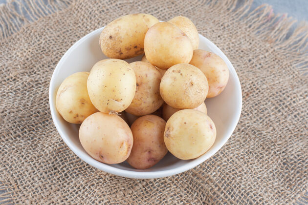 土豆装满煮土豆的碗放在袋子上配料棕色自然