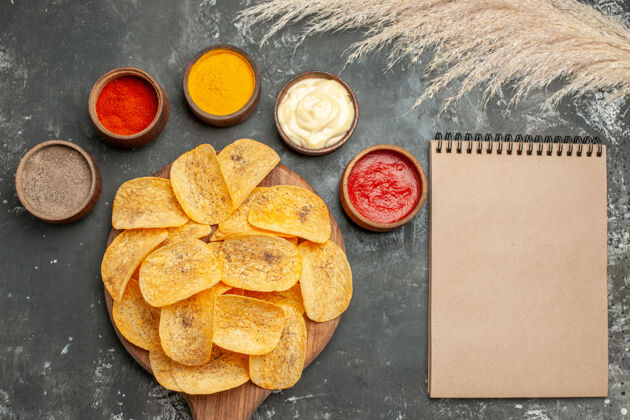 笔记本放在笔记本旁边的薯片里 里面有不同的香料 蛋黄酱和番茄酱封闭不同薯片