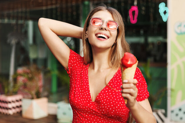 微笑一个快乐的女人吃冰淇淋的户外街道肖像冰淇淋梦幻太阳镜