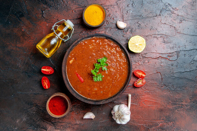 食物番茄汤在一个棕色的碗和不同的香料大蒜柠檬混合颜色表容器汤混合物