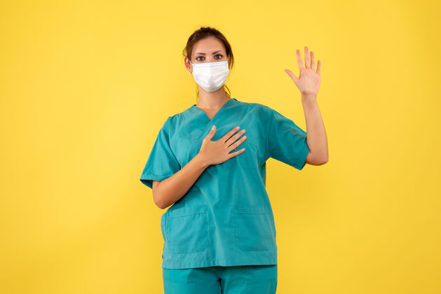 正面前视图黄色背景上穿着医用衬衫和面罩的女医生人病毒视图