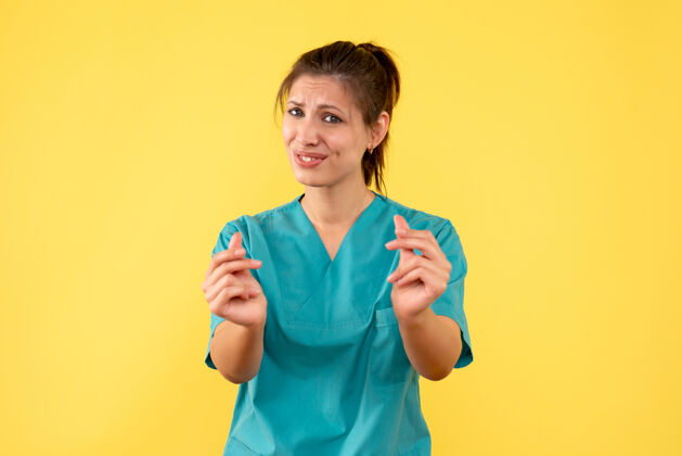 肖像前视图黄色背景上穿着医用衬衫的女医生健康衬衫成人