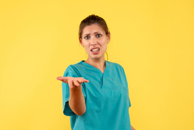 衬衫前视图黄色背景上穿着医用衬衫的女医生黄色视图肖像