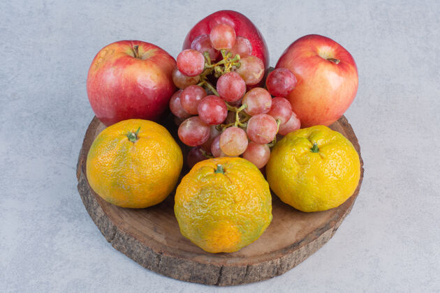 集团新鲜的有机水果苹果 葡萄和橘子放在木板上灰色美味柑橘