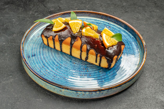 封闭式黑桌子上用橘子和巧克力装饰的软蛋糕的特写镜头餐厅盘子软蛋糕
