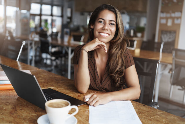 大学成功的西班牙裔女性微笑着在咖啡馆工作教师技术笔记本电脑