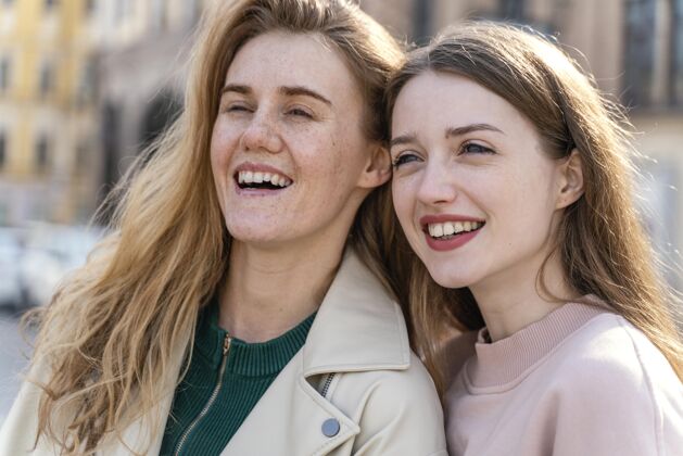 休闲两个微笑的女性朋友在城市户外娱乐城市城镇