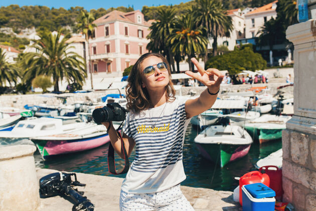有趣迷人的女人在欧洲海边度假 在游轮上用相机拍照时尚旅游人