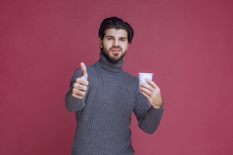 工作人员男人拿着一个一次性咖啡杯 做着享受的手势美味人人类