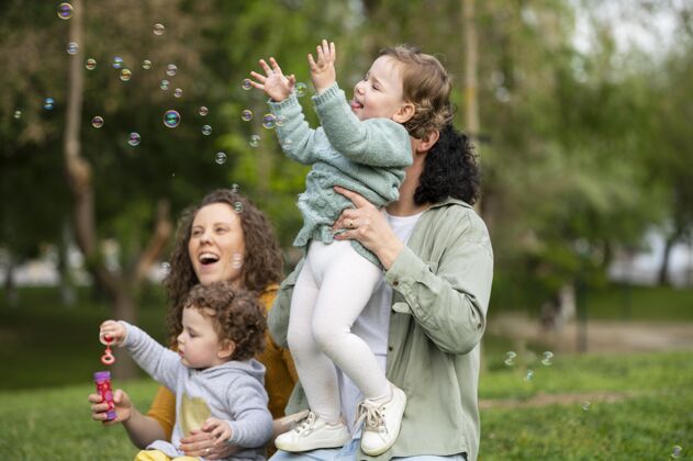 肥皂泡快乐的孩子们在公园里和同性恋妈妈们在一起婴儿夫妇Lgbt家庭