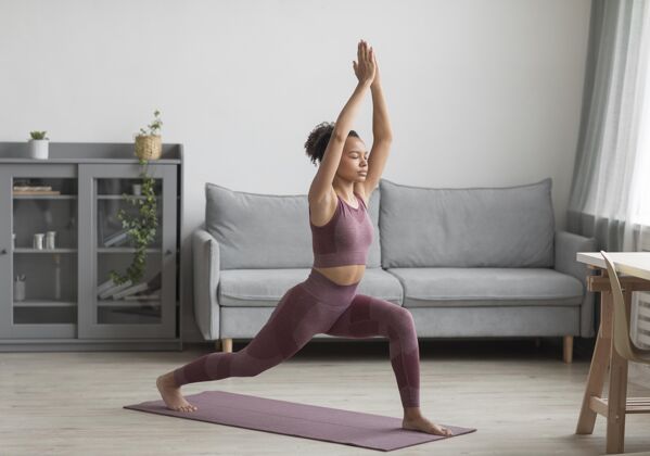 心灵健身女士在家里用瑜伽垫做瑜伽人体锻炼身体
