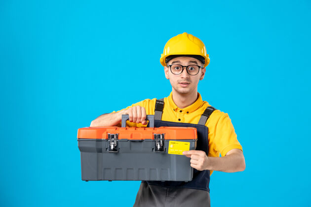 服务穿着黄色制服的男工人的正面图 蓝色的是银行卡和工具箱承包商杂工建筑