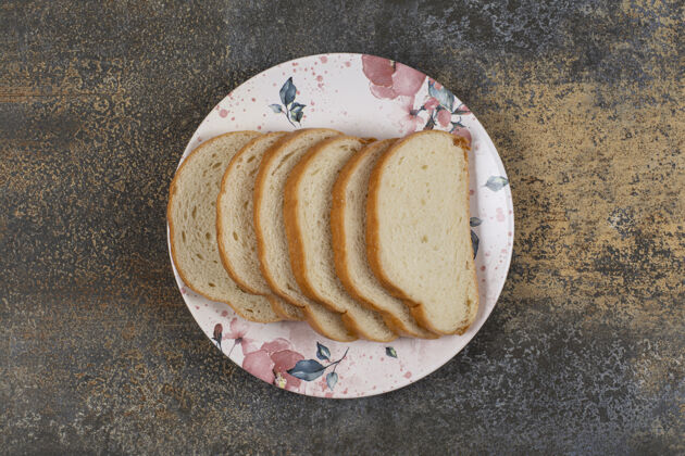 小吃美味的白面包片放在五颜六色的盘子里有机膳食早餐