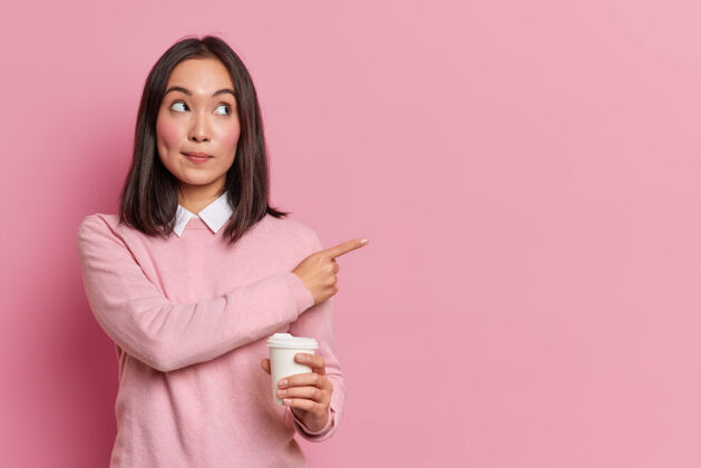 水平迷人的黑发亚裔女性把一次性咖啡杯放在一边 展示空白处广告促销地点穿着休闲服建议去咖啡厅喝一杯衣服饮用一次性
