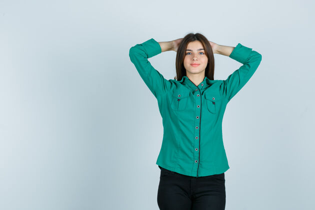 单身年轻的女性手牵着手 头后穿着绿色的衬衫 裤子 神情自豪 俯瞰前方漂亮人办公室