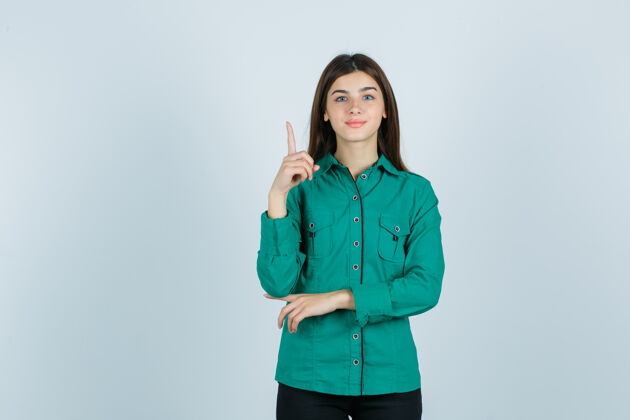 年轻一幅年轻女性的画像 她穿着绿色衬衫朝上 看上去很快乐无忧无虑节日指向