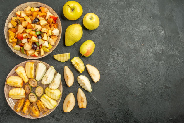 盘子黑暗背景下新鲜水果切片的水果沙拉俯视图一餐玉米晚餐