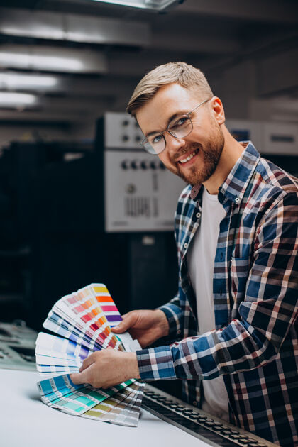 工程师在印刷厂用纸和颜料工作的人设备颜色设计师