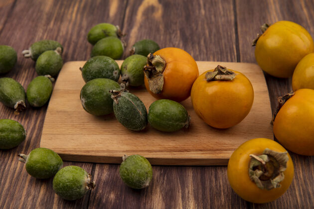 营养新鲜的橙色柿子水果的俯视图 在木制厨房板上的木制表面上有飞珠甜点饮食美味