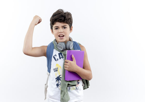 抱着自信的小男生背着书包戴着耳机拿着书做着坚强的手势自信小学生学生