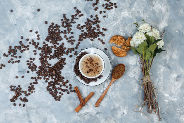 咕噜俯瞰咖啡与研磨咖啡 咖啡豆 鲜花 肉桂棒 饼干在肮脏的灰色背景水平热的新鲜的