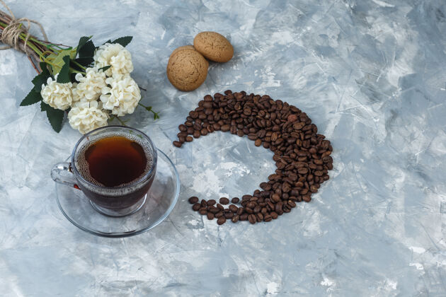 咖啡俯视一杯咖啡 咖啡豆饼干 浅蓝色大理石背景上的花朵水平艺术豆子杯子