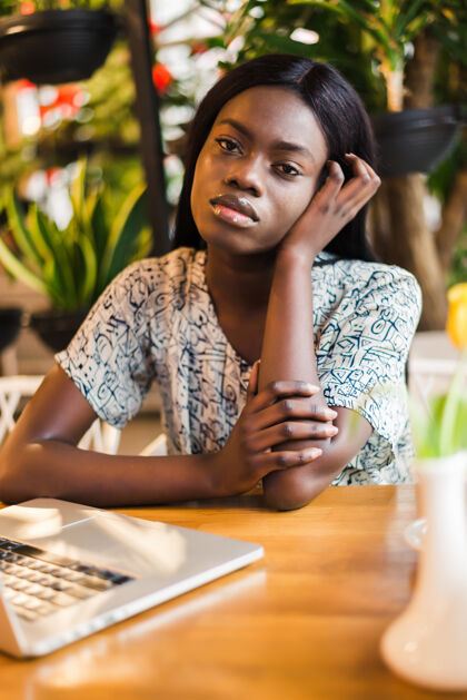 自由职业者在咖啡馆里拿着笔记本电脑的非裔美国自由职业女性年轻非洲工作