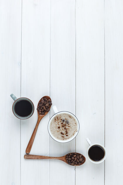 卡布奇诺带咖啡豆的杯子里的咖啡木制背景上的顶视图乡村的袋子咖啡馆