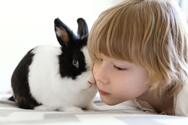 男孩把孩子和可爱的兔子放在一起房子室内内部