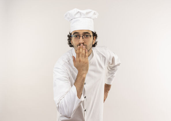 男性年轻的男厨师穿着厨师制服 戴着眼镜 用手捂住嘴巴厨师手烹饪