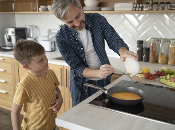 孩子中等身材的爸爸在做煎蛋水平家庭男人